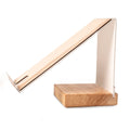 Side view of a modern, angular cell phone stand with a white metal frame and a rectangular wooden base, designed for hands-free viewing with an integrated charging slot.