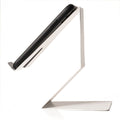 A smartphone positioned on a sleek, white cell phone holder, viewed from the side to show its angled design and minimalist structure.