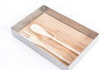 Metal container with a smooth wooden base, holding a wooden spoon and fork placed side by side.