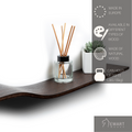Dark wooden wavy shelf holding a reed diffuser and a succulent. Made in Europe, natural wood, supports up to 11 lbs.