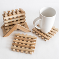 Handmade wooden coasters in a lattice pattern displayed with a white mug on one. Showcasing their natural wood tones and craftsmanship.