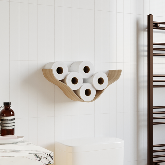 Wooden wall shelf with a cloud-like, curved design holding five rolls of toilet paper, mounted on white tiled walls in a modern bathroom next to a toilet and towel rack.