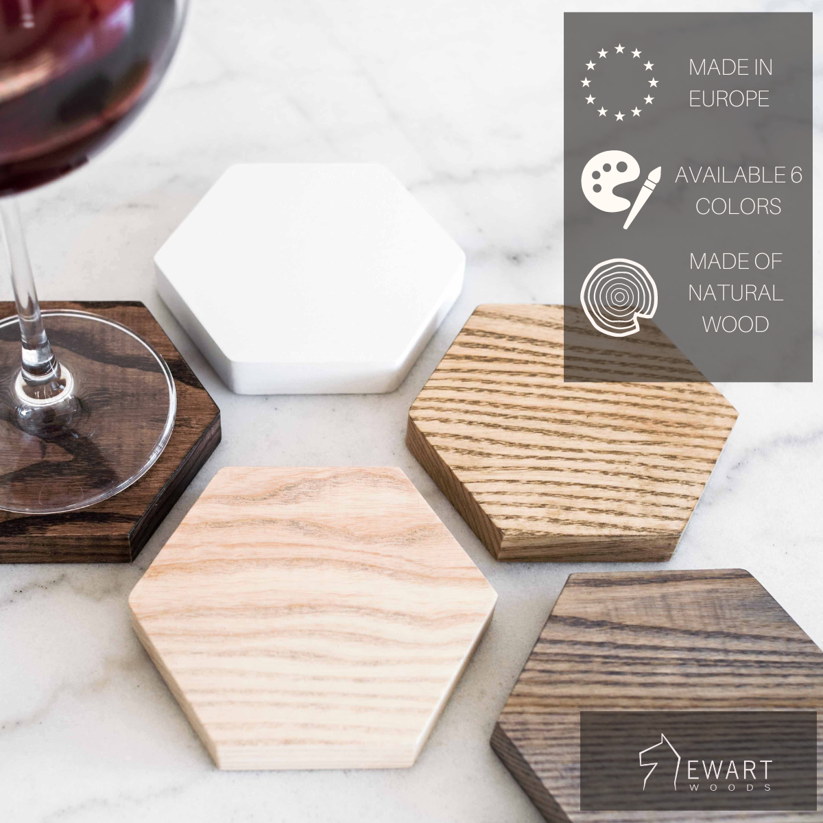 A close-up of a set of hexagonal wooden coasters in various colors, with a glass of red wine placed on one coaster. The text highlights the product's European origin, availability in six colors, and its natural wood composition.