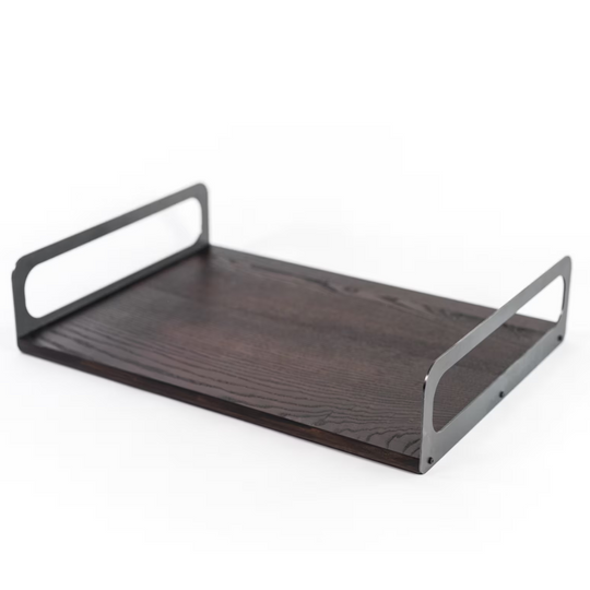 Wooden serving tray with a dark ash finish, featuring a smooth, textured surface and sleek metal handles, showcasing its minimalist design.