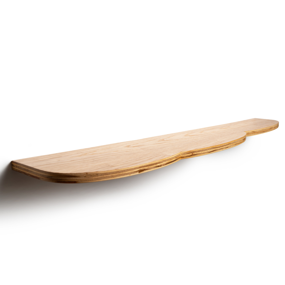 Curved wooden shelf with a smooth, light wood finish, mounted on a wall, viewed from a side angle.