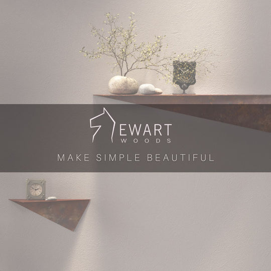 Rustic metal decor shelves with textured surfaces, displaying a decorative plant, smooth stones, a black vase, and a clock. The image features the &