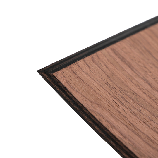 Close-up of the edge of a curved wooden holder made from walnut, showing the wood grain and smooth finish.
