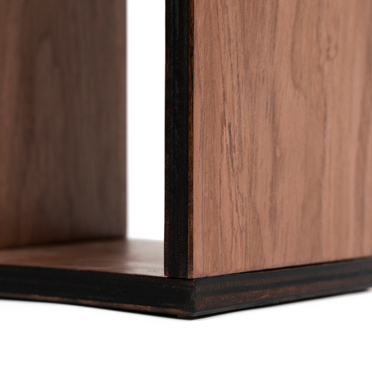 Close-up of a dark walnut veneer toilet paper holder with smooth wood grain texture and stained edges. The layered birch plywood construction is visible, highlighting its craftsmanship.