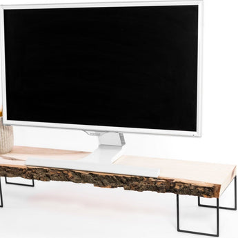 Close-up of a computer monitor on a modern wooden stand featuring a natural bark edge and a refined, smooth surface, supported by minimalist black metal legs.