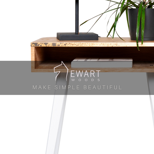 Close-up of rectangular wooden nightstand with brass design and white wooden legs