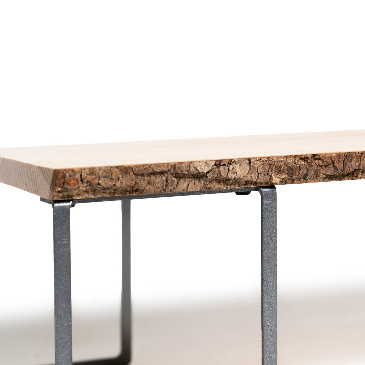 Close up of wooden monitor stand with tree bark and metal legs