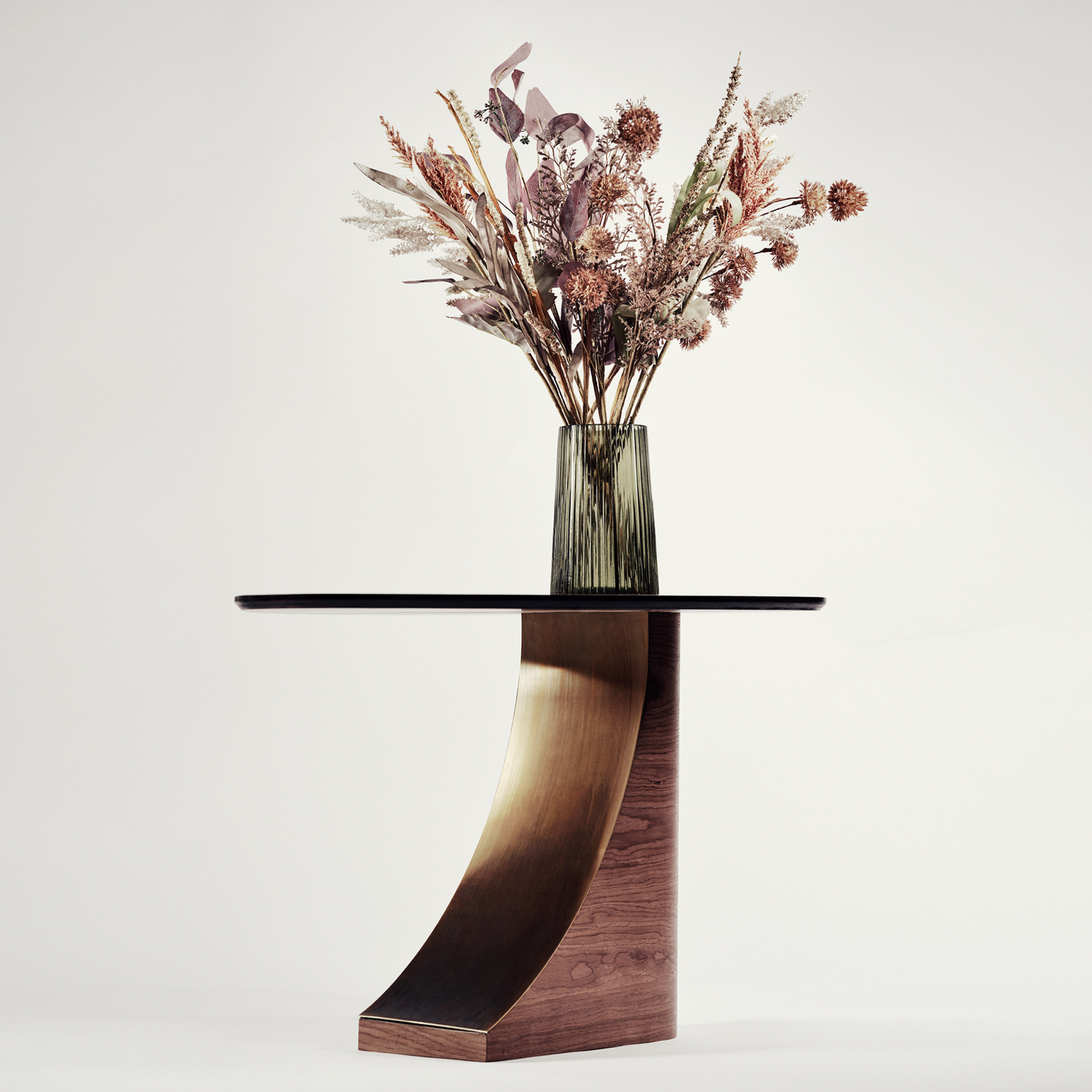 Modern side table with wooden base and glass top, featuring a vase with dried flowers on a white background.
