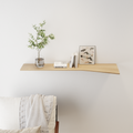 floating wall shelf with curved edge light wood attached to white wall with books, vase and painting on the shelving