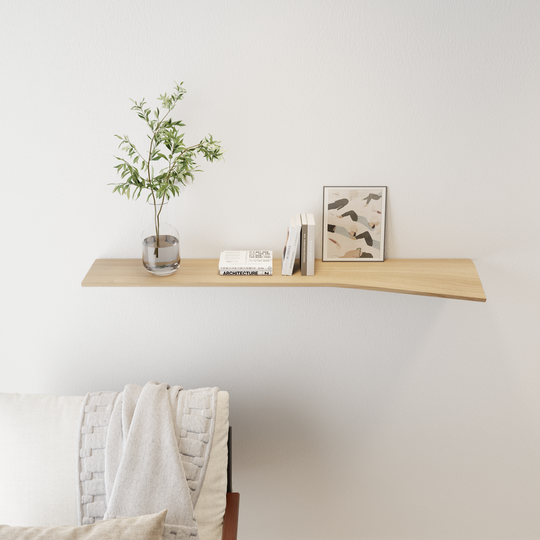 floating wall shelf with curved edge light wood attached to white wall with books, vase and painting on the shelving