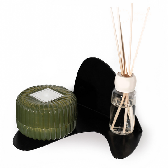 Sleek black metal wall bracket with a curved design, offering durability and a minimalist look. It holds a ribbed green container and a glass reed diffuser, blending functionality with contemporary style.
