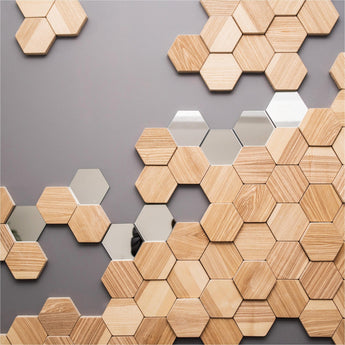 Hexagonal wooden wall tiles combined with mirrored accents create a geometric, modern decor pattern on a grey background.