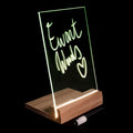 Light Glowing glass panel mounted on a wooden base, displaying the handwritten text &