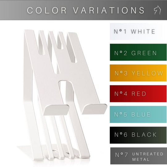 Modern white metal phone stand featuring a grooved design with a charging slot, shown next to a palette of color options including white, green, yellow, red, blue, black, and raw metal.