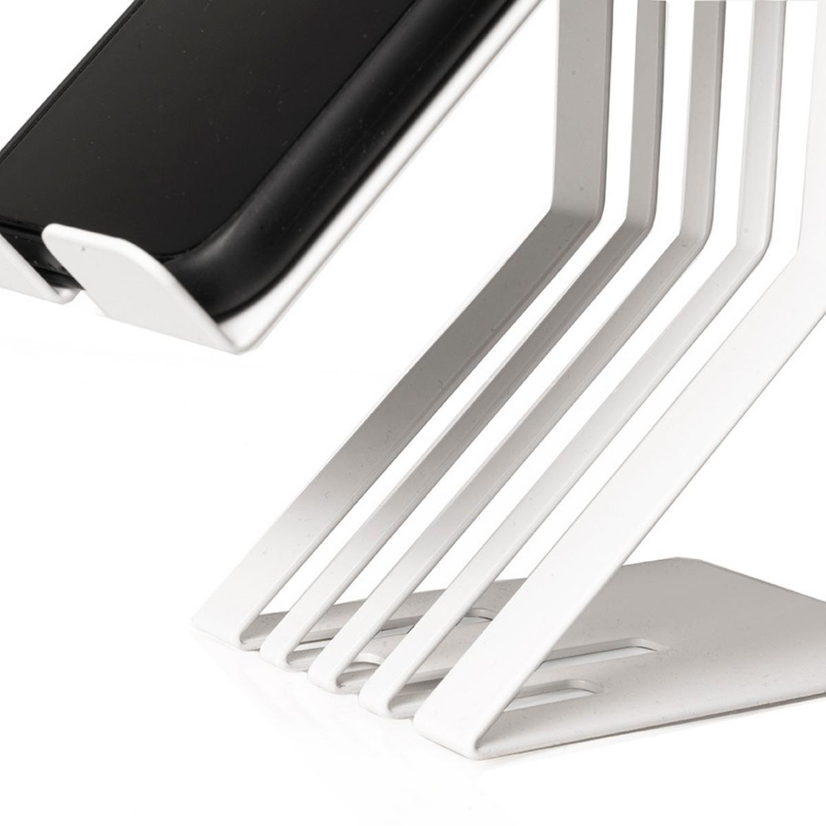 Close-up of a white metal phone holder with a slatted design, emphasizing the modern, minimalist design and integrated charging slot.
