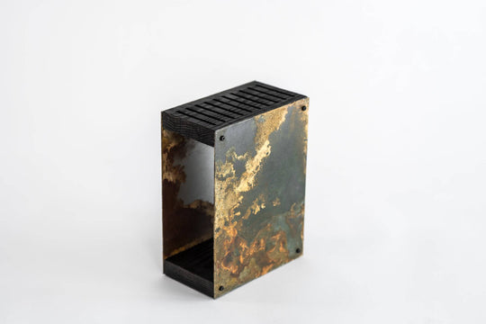 Industrial-style knife block featuring a weathered, rustic steel finish with a patina effect, along with a dark wooden top and base. The block is displayed against a plain white background.