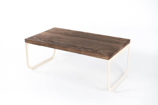 Minimalist serving tray with a dark wooden surface and light-colored metal legs, set against a white background.