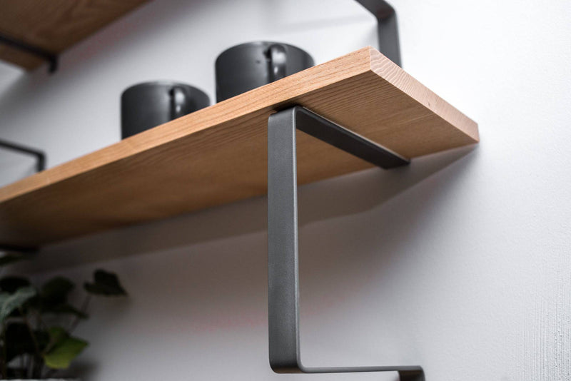 Side view of wooden shelf with geometric metal brackets wall mounted natural wood