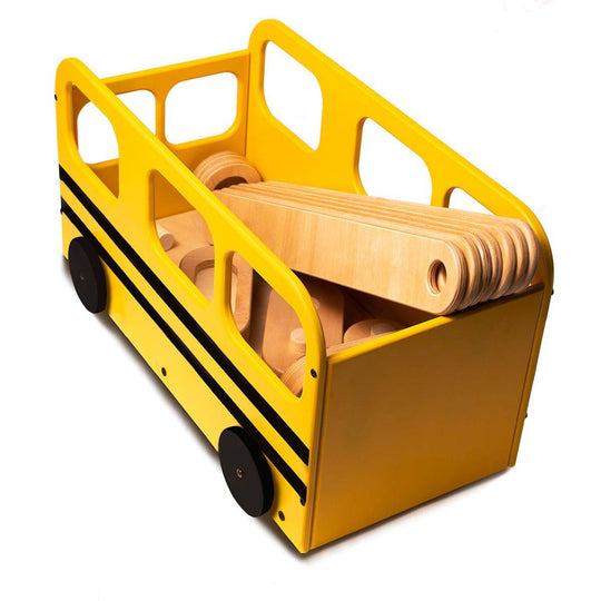 Yellow wooden toy bus with black wheels, filled with a wooden balance beam set, resembling a school bus.