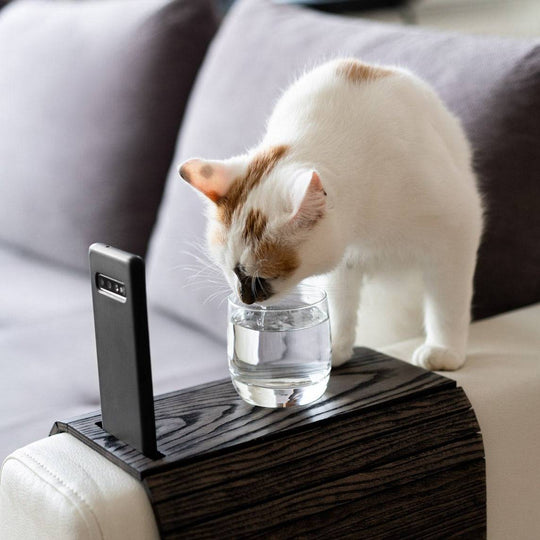 Burned Wooden Sofa Arm Tray Table on a couch arm, showcasing its versatility and stylish burnt wood finish. EWART WOODS