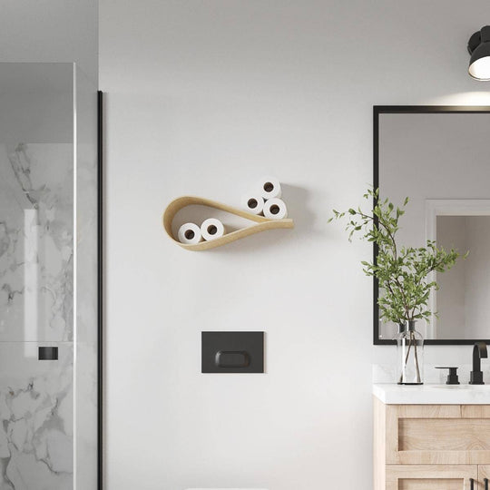 Birch drop-shaped floating toilet paper rack mounted on a bathroom wall, holding five toilet paper rolls. The bathroom showcases a clean, minimalist aesthetic with wooden elements, a contemporary mirror, and stylish fixtures.